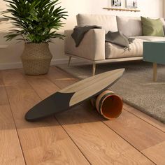 a surfboard laying on the floor next to a potted plant in a living room