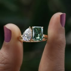 a woman's hand holding a three stone ring