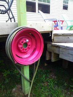 a pink frisbee sitting on top of a green pole next to a wooden bench