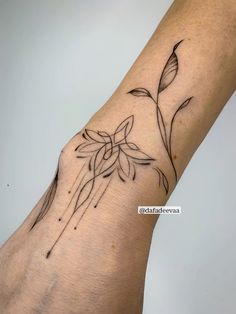 a person's hand with a flower tattoo on the left side of their arm