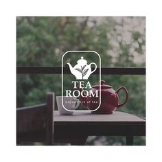 the tea room logo is displayed on top of a table with a tea pot next to it