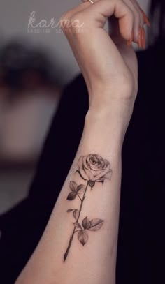 a woman's arm with a rose tattoo on it