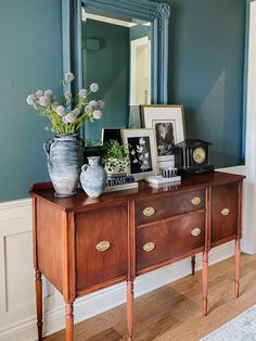 a dresser with flowers and pictures on it