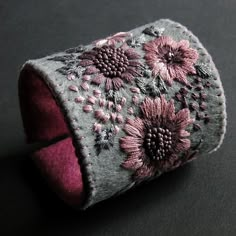 a gray and pink flowered cuff on a black surface