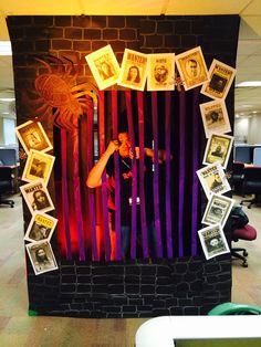 a man standing in front of a wall with pictures on it