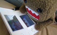 a stuffed animal that is sitting next to an electronic device with a shark face on it