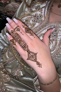 a woman's hand with henna tattoos on it