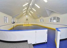 an indoor gym with blue and yellow flooring, white walls and windows on the ceiling