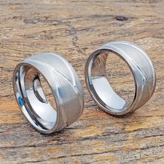 two wedding rings sitting on top of a wooden table