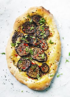 a pizza topped with sliced eggplant and pepper sprinkled on top of it