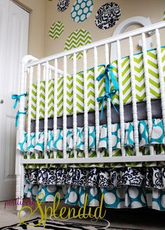 a white crib with blue and green bedding