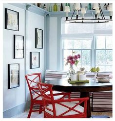 a dining room with blue walls and pictures on the wall above the dinning table