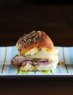 a ham and cheese sandwich on a plate with mustard sprinkled on the bun