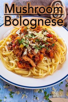 a white plate topped with pasta covered in mushroom bolognzoe next to a knife and fork