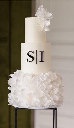 a three tiered cake with white flowers on top