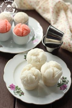 three small desserts sitting on plates next to a teapot and cupcake tin