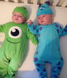 two babies dressed in costumes laying next to each other on top of a crib