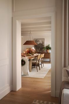 a dining room table with candles on it in the middle of a living room area