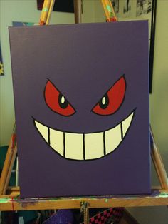 a purple bag with red eyes and big teeth on it's face is sitting on a easel