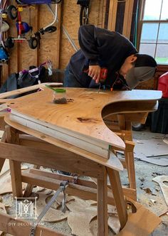 a man in a black hoodie working on a wooden table