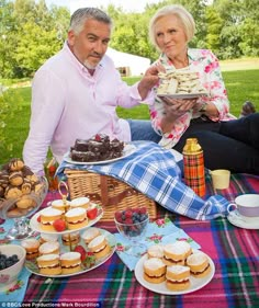 a man and woman sitting at a picnic table with pastries on the trays