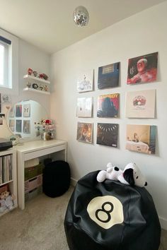 there is a black bean bag in the corner of this room with pictures on the wall