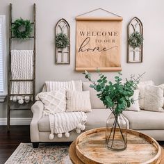 a living room with a couch, coffee table and potted plant in the corner