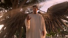 a man dressed in white with wings outstretched