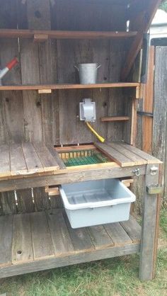 an outdoor kitchen made out of wooden pallets with tools on top and buckets in the back