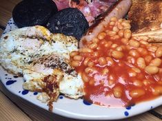 a white plate topped with eggs, beans and toast