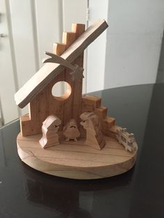 a wooden nativity scene is displayed on a table