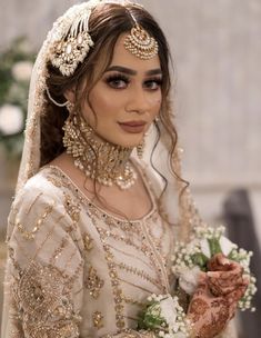 a woman wearing a bridal outfit and jewelry