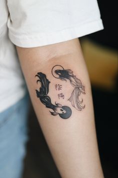 a woman with a tattoo on her arm that has two fish in it and flowers