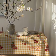 a vase with white flowers sitting on top of a table next to a plate and cup