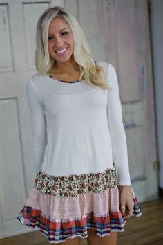 a woman wearing a white top and colorful skirt