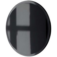 a black round mirror with a cross on the front and bottom part of it's frame