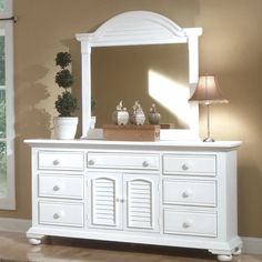 a white dresser and mirror in a room