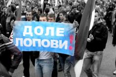 a group of people walking down a street with signs in russian and english on them