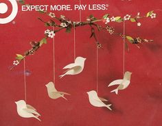 a red poster with white birds hanging from it's sides and the words expect more pay less