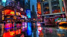 a city street filled with lots of traffic and tall buildings covered in neon lights at night