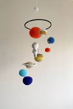 a crocheted mobile with planets hanging from it