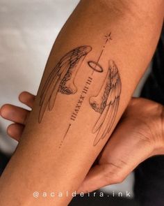 a woman's arm with an angel tattoo on the left side of her arm