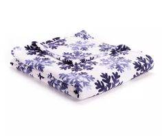 the blue and white flowered blanket is folded on top of each other, with two pillows