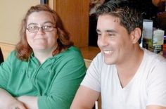 two people sitting at a table smiling for the camera