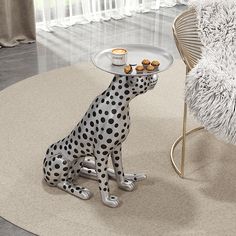 a dalmatian dog sitting in front of a table with some food on it