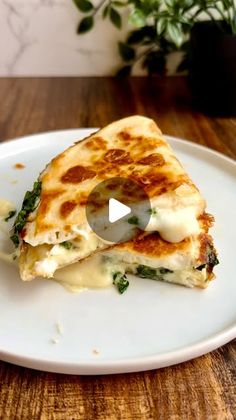 a white plate topped with a quesadilla cut in half on top of a wooden table