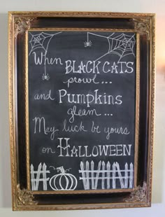 a chalkboard with writing on it in a gold frame hanging on the wall next to a light