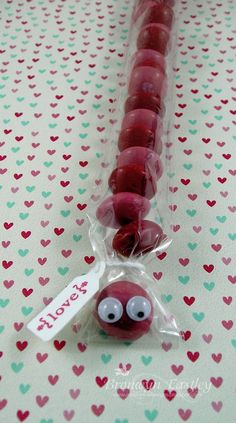 a close up of a candy bead on a table with hearts in the background