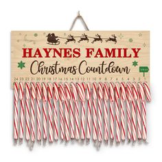 christmas candy canes hang from a wooden sign