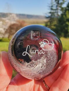 a hand holding a crystal ball with the word luna written on it